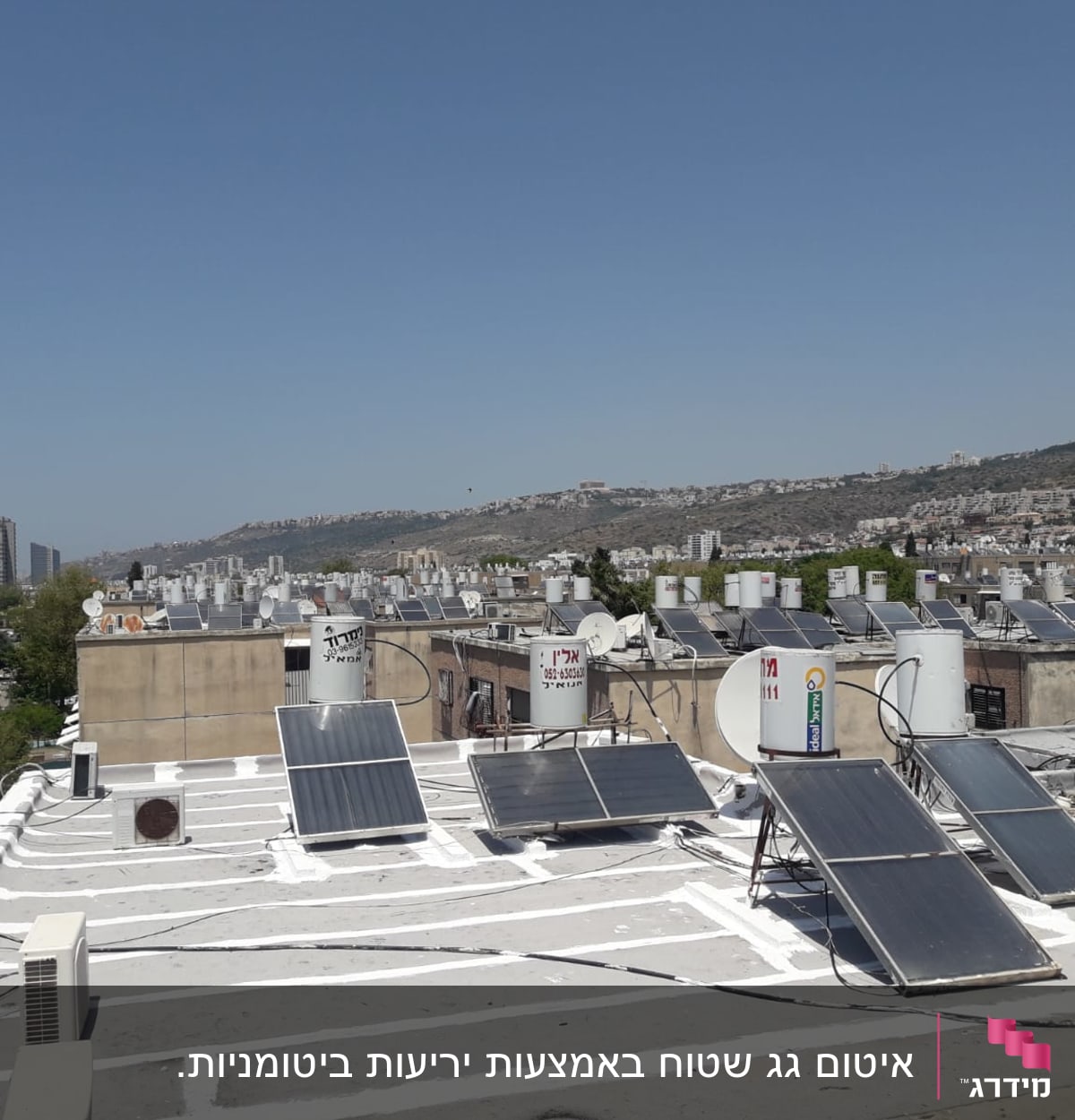 גג עם קולטי שמש ואיטום לבן מסביב